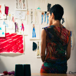 Female fashion designer contemplating drawings in studio